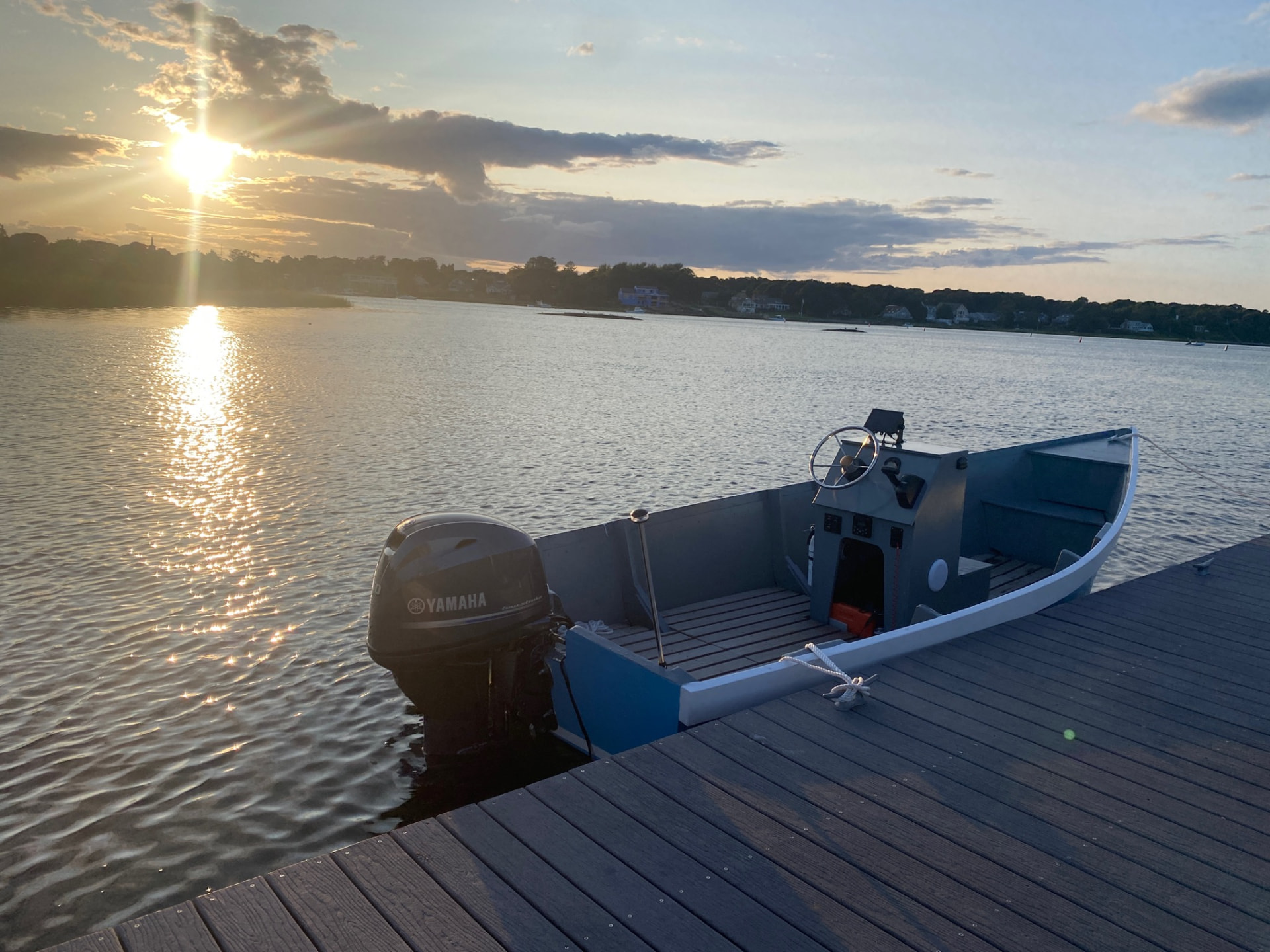 Blue Lady Bug skiff tied alongside a dock at sunset